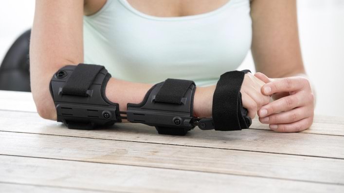 Woman easily putting on Omo Neurexa brace with one hand