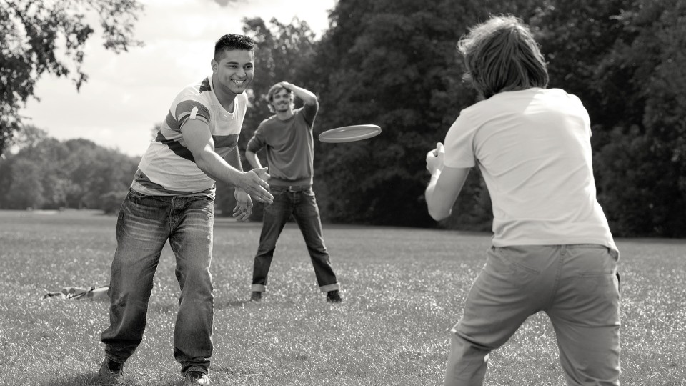 Hamed with Genium prosthesis playing frisbee with friends.