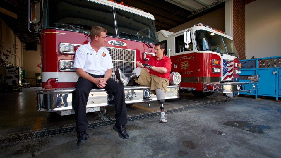 Neil at the fire station with his Harmony prosthetic legs.