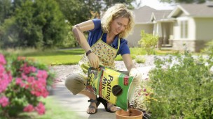 Sherri with DynamicArm prosthesis planting potted flowers.
