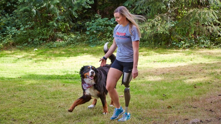 Ali walking with her dog while using her Genium knee