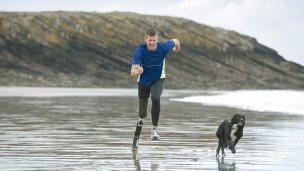 John with Running prosthesis taking a run on the beach.