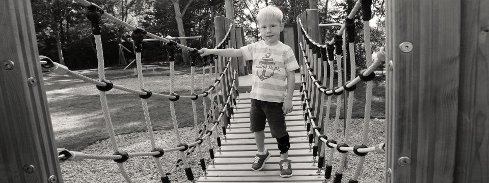 Junge steht mit WalkOn Reaction junior auf einer Hängebrücke