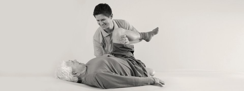 Therapist helping an amputee patient stretch his leg