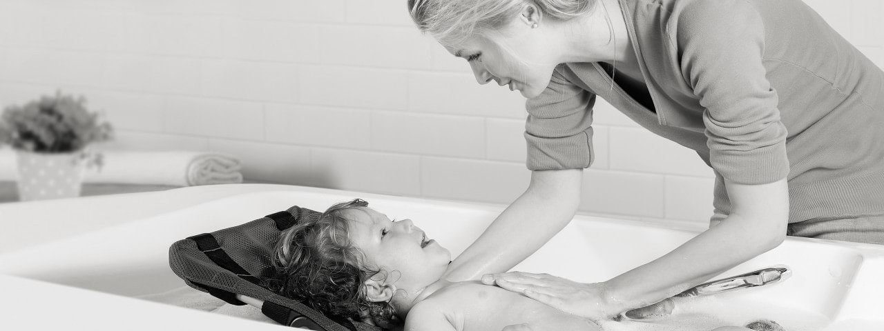 Mother bathing her child in the Leckey Bath Support.