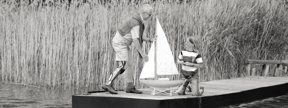 Peter mit Orthesensystem E-MAG Active spielt mit Enkel auf Bootssteg