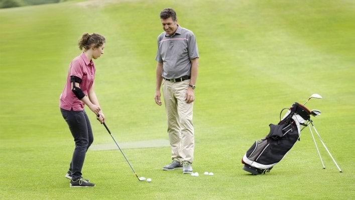 Ottobock Omo Neurexa Armorthesen Anwenderin beim Golfspielen mit Lehrer