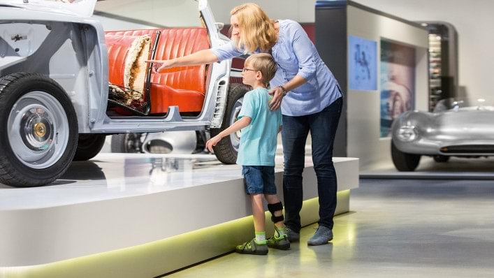 Mother and son looking at a classic car. The boy is wearing the WalkOn Reaction junior, a dynamic ankle-foot orthosis from Ottobock