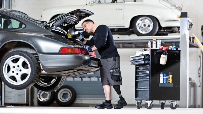 Feri ispeziona il vano motore di una Porsche.