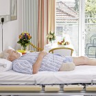 A man with a leg amputation is lying on his back in the hospital bed.