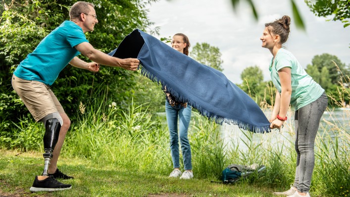 Péter leteríti lányaival a piknik takarót.