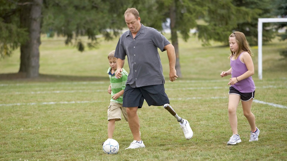 Jonathan with C-Leg prosthesis playing soccer with his children.