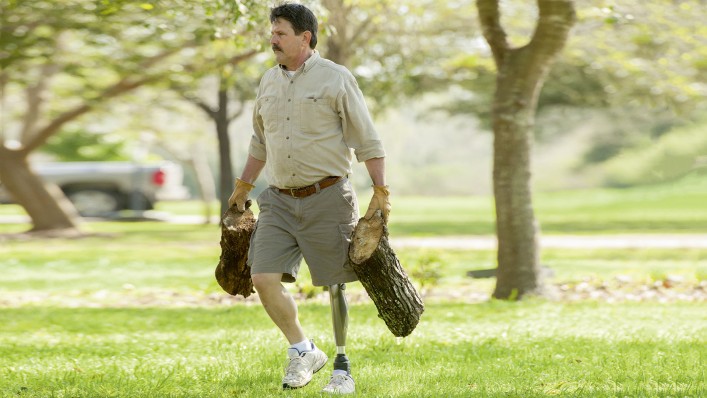 Plenty to do on the farm: Robert carries sawn tree stumps across a meadow