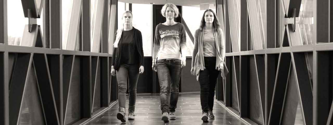 3 Frauen laufen durch einen Gang
