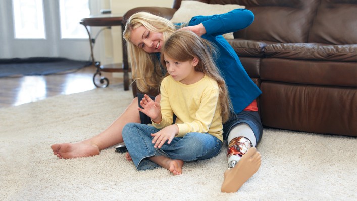 Brecklyn with her daughter in front of the sofa using a carbon fibre foot