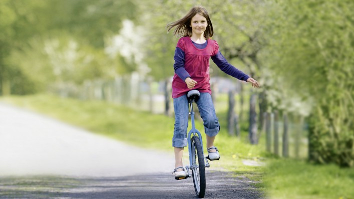 Kind mit Armprothesensystem fährt Einrad 