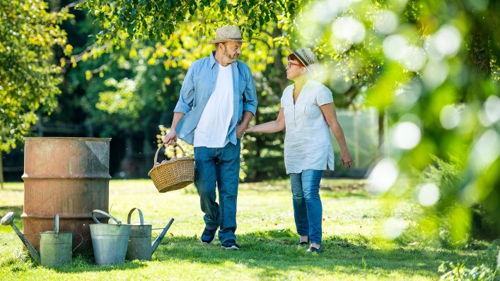 Ein Mann, der zwei Prothesen mit der aktiven Vakuumpumpe DVS (Dynamic Vacuum System) trägt, und seine Frau gehen gemeinsam durch den Garten