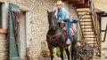 Eine Frau, die eine Prothese mit der aktiven Vakuumpumpe Harmony trägt, schwingt sich auf ein Pferd.