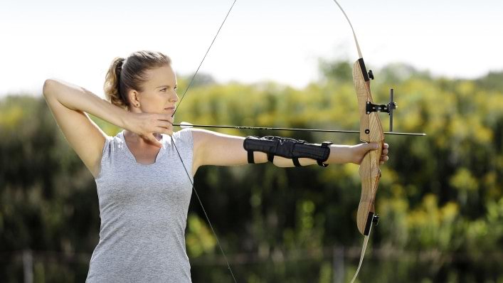 Woman with orthosis uses bow.