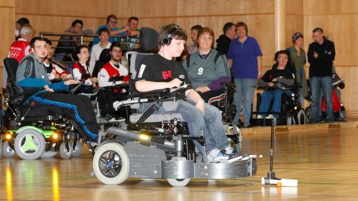 Power wheelchair user with ball. 