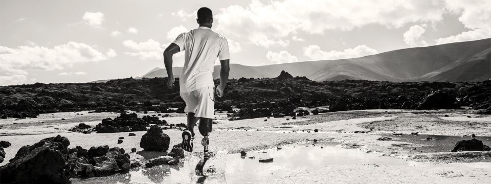 Läufer mit Prothese in Landschaft.