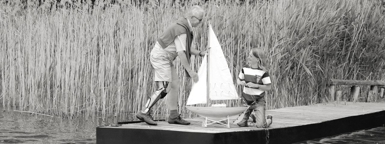 Peter portant son orthèse E-MAG Active et enfant jouant avec un petit navire