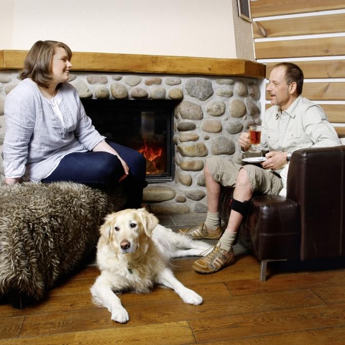 Jürgen with WalkOn sitting at the fireplace with girl friend & dog