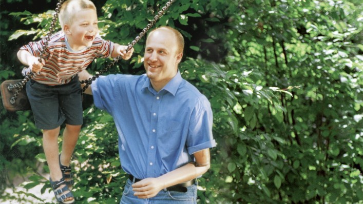 User with DynamicArm prosthesis pushing his child on a swing.
