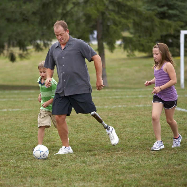 Jonathan with C-Leg prosthesis playing soccer with his children.