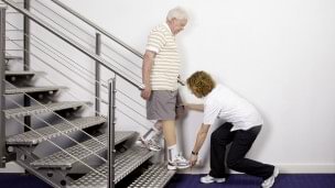Therapist explains the rehabilitation exercise how to go down stairs.