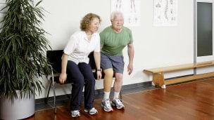 Therapist explains the rehabilitation exercise how to sit down.