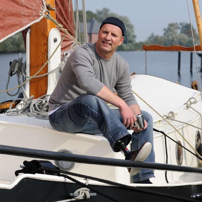 Carsten with Harmony prosthesis sitting on his sail boat.